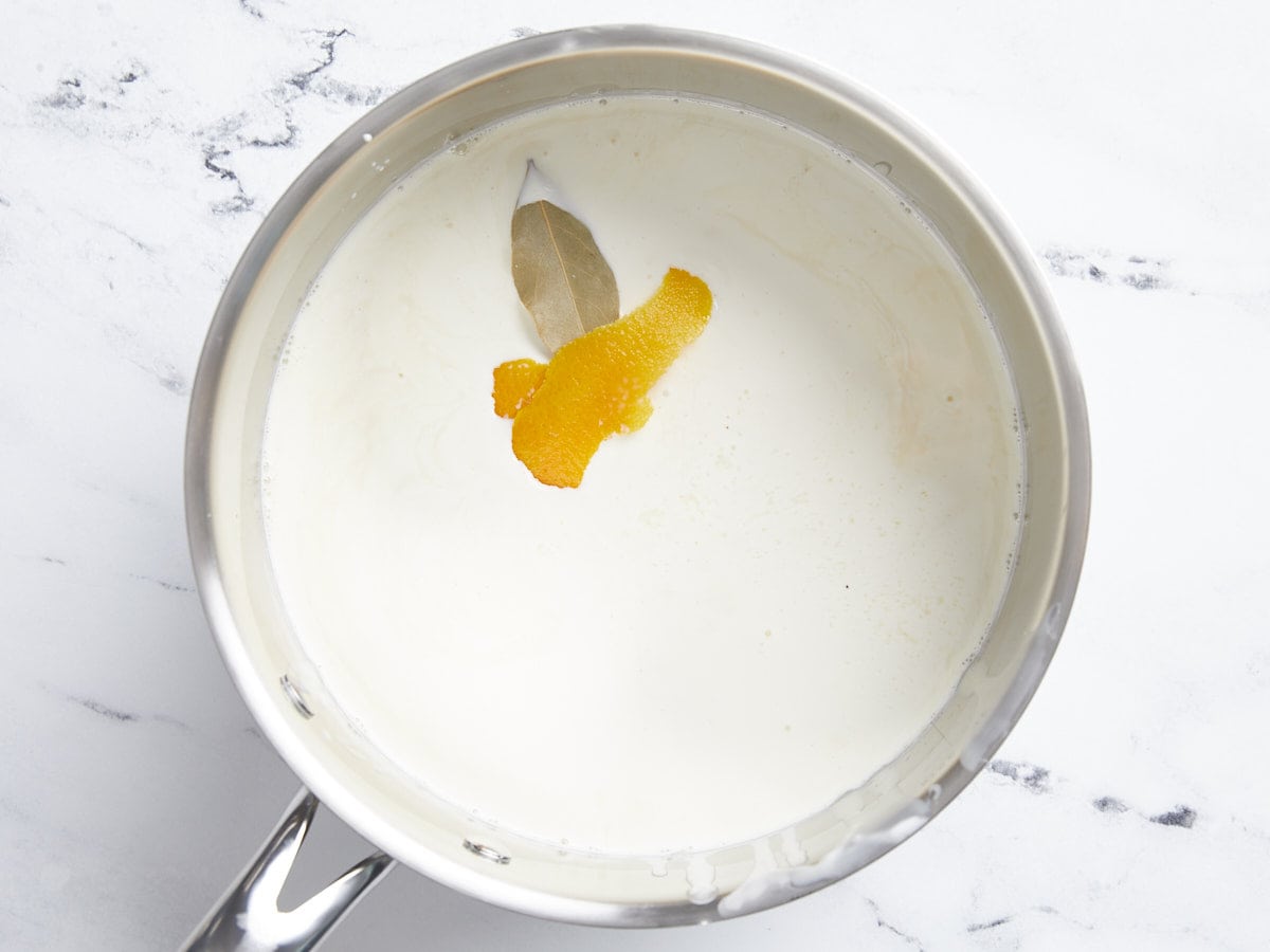 Milk, bay leaf, and zest in a pot.