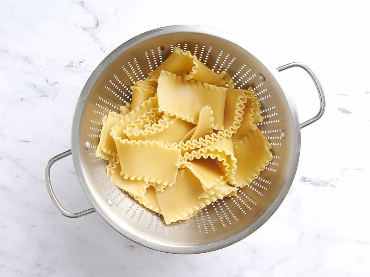 Cooked lasagna noodles in a colander.