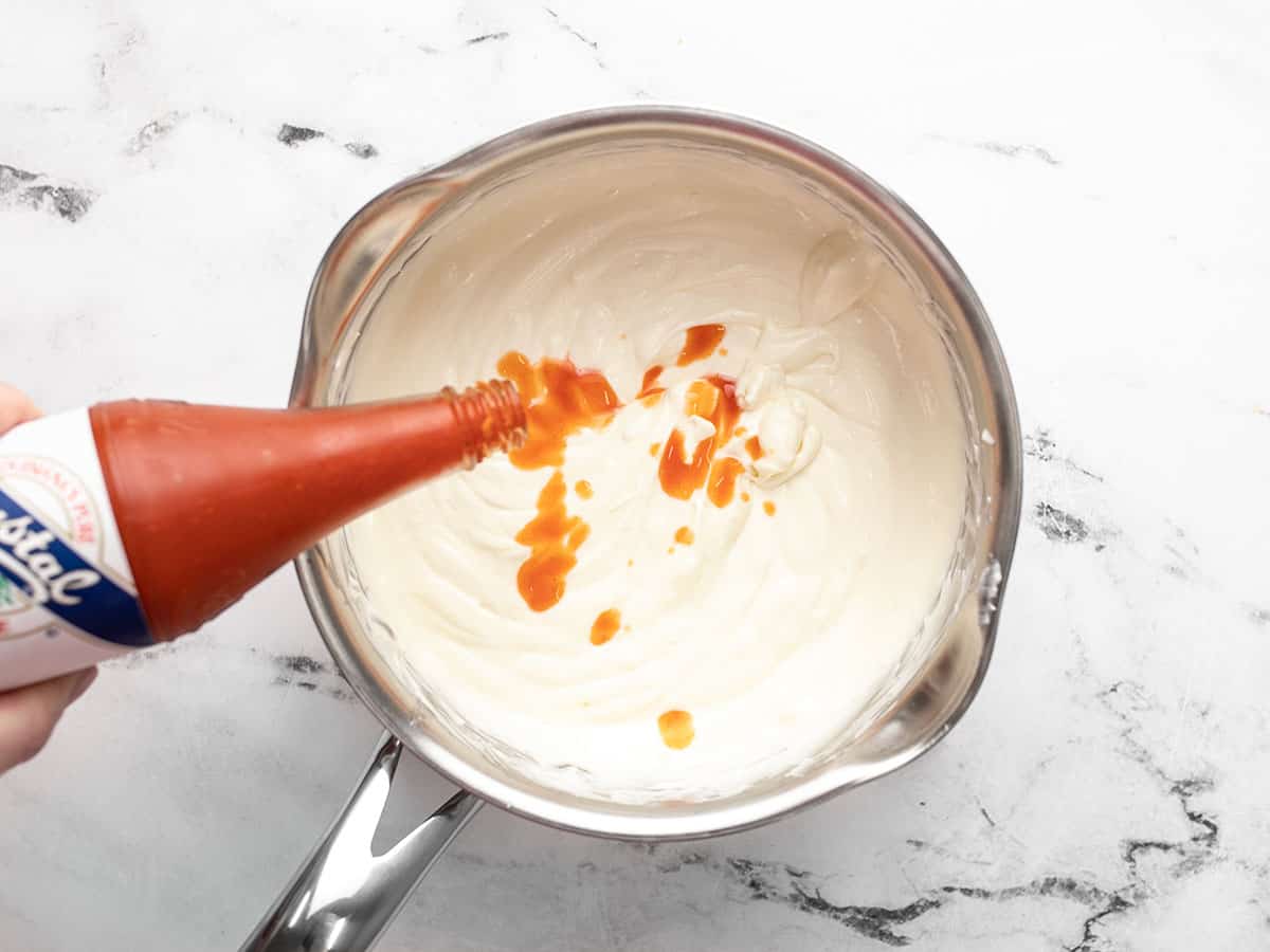 Hot sauce being added to the saucepot.