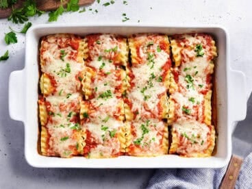 Overhead view of lasagna roll ups in a baking dish.