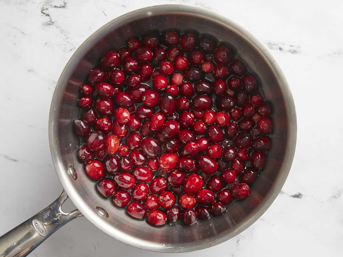 Fresh cranberries added to the pot with the water and sugar.