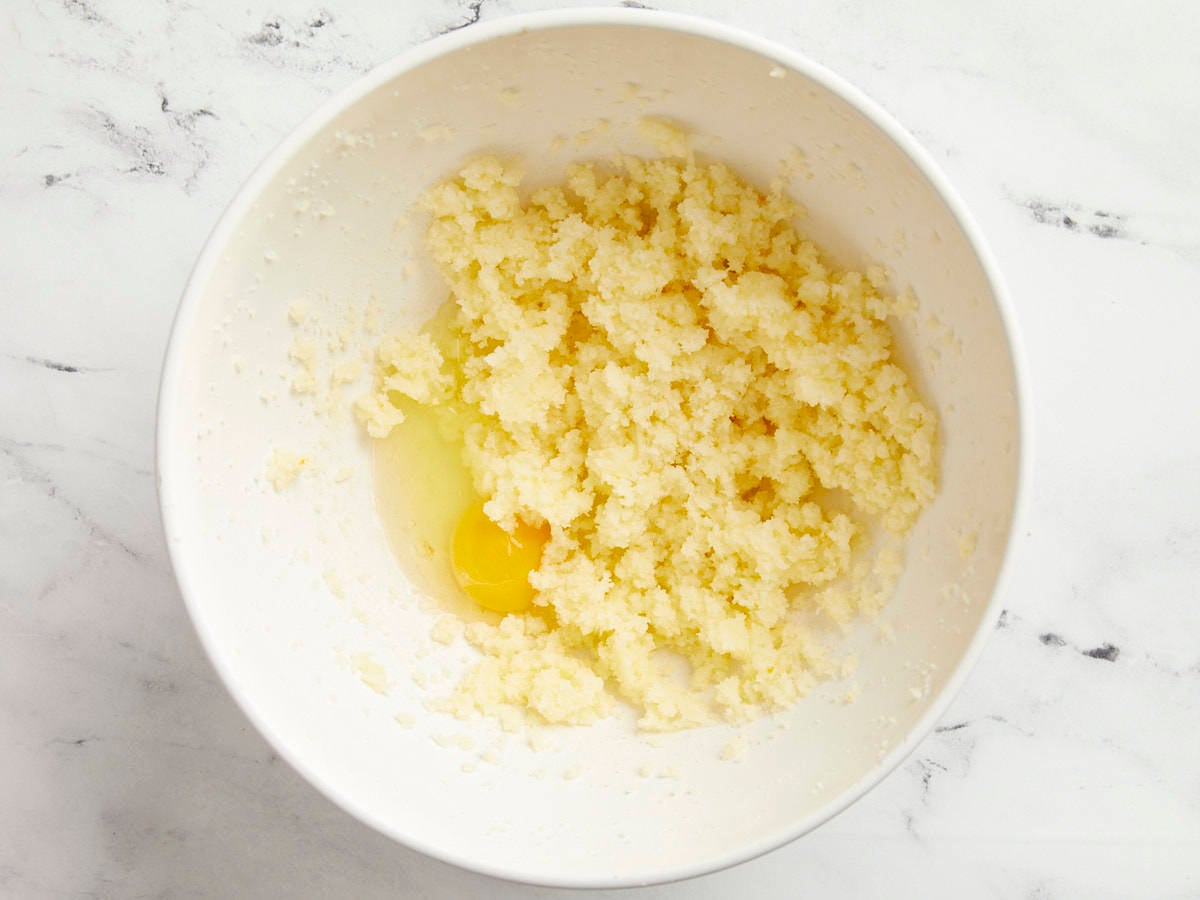 Creamed butter and sugar in a bowl with eggs added.