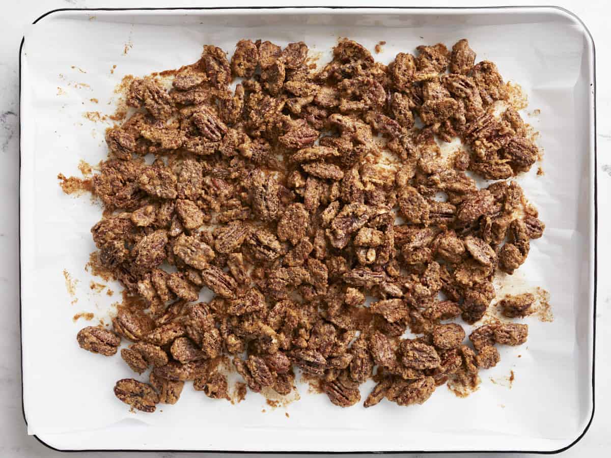 Baked candied pecans on the baking sheet.