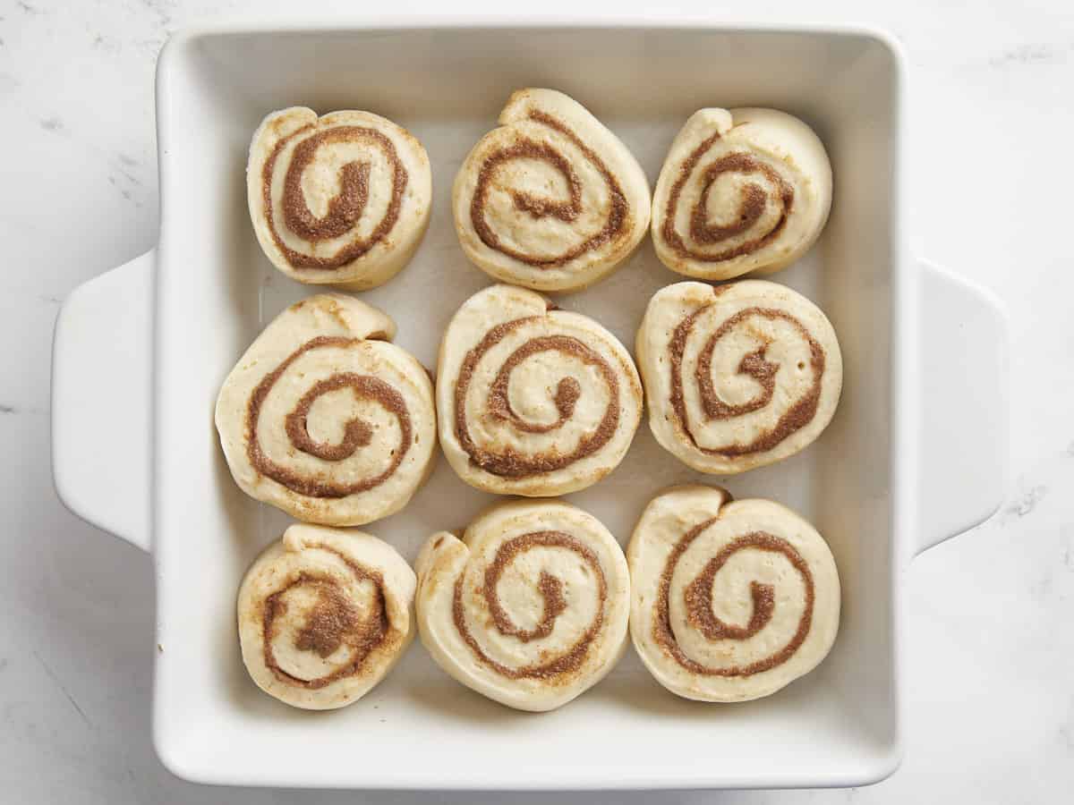 Cinnamon rolls placed into a baking dish.