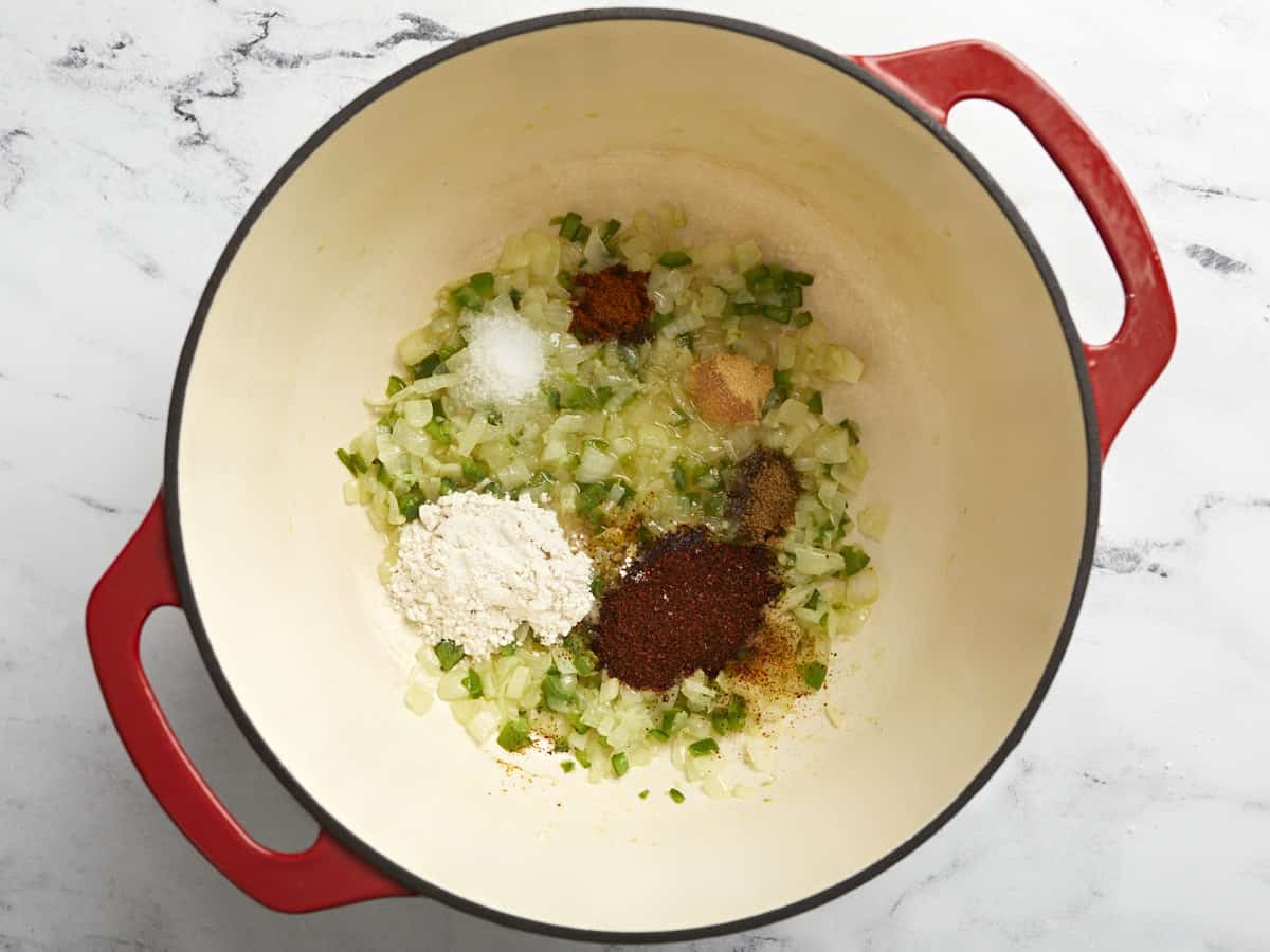 Spices added to sautéed vegetables in a Dutch oven.