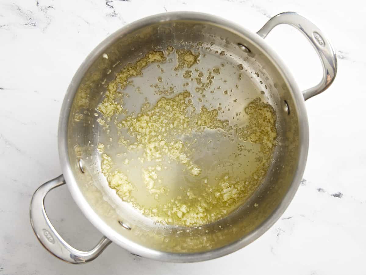 Minced garlic in a soup pot with olive oil.