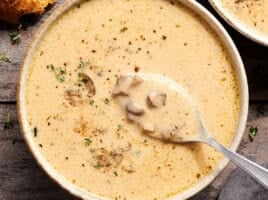 Overhead view of creamy mushroom soup in a bowl with a spoon.