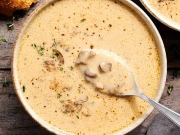 Overhead view of creamy mushroom soup in a bowl with a spoon.