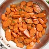 Overhead view of glazed carrots in a sauté pan.