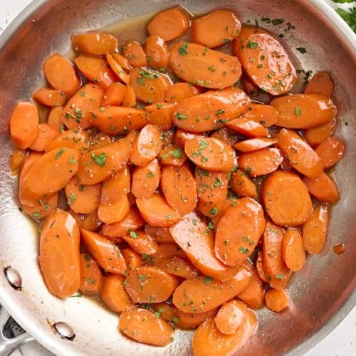 Overhead view of glazed carrots in a sauté pan.