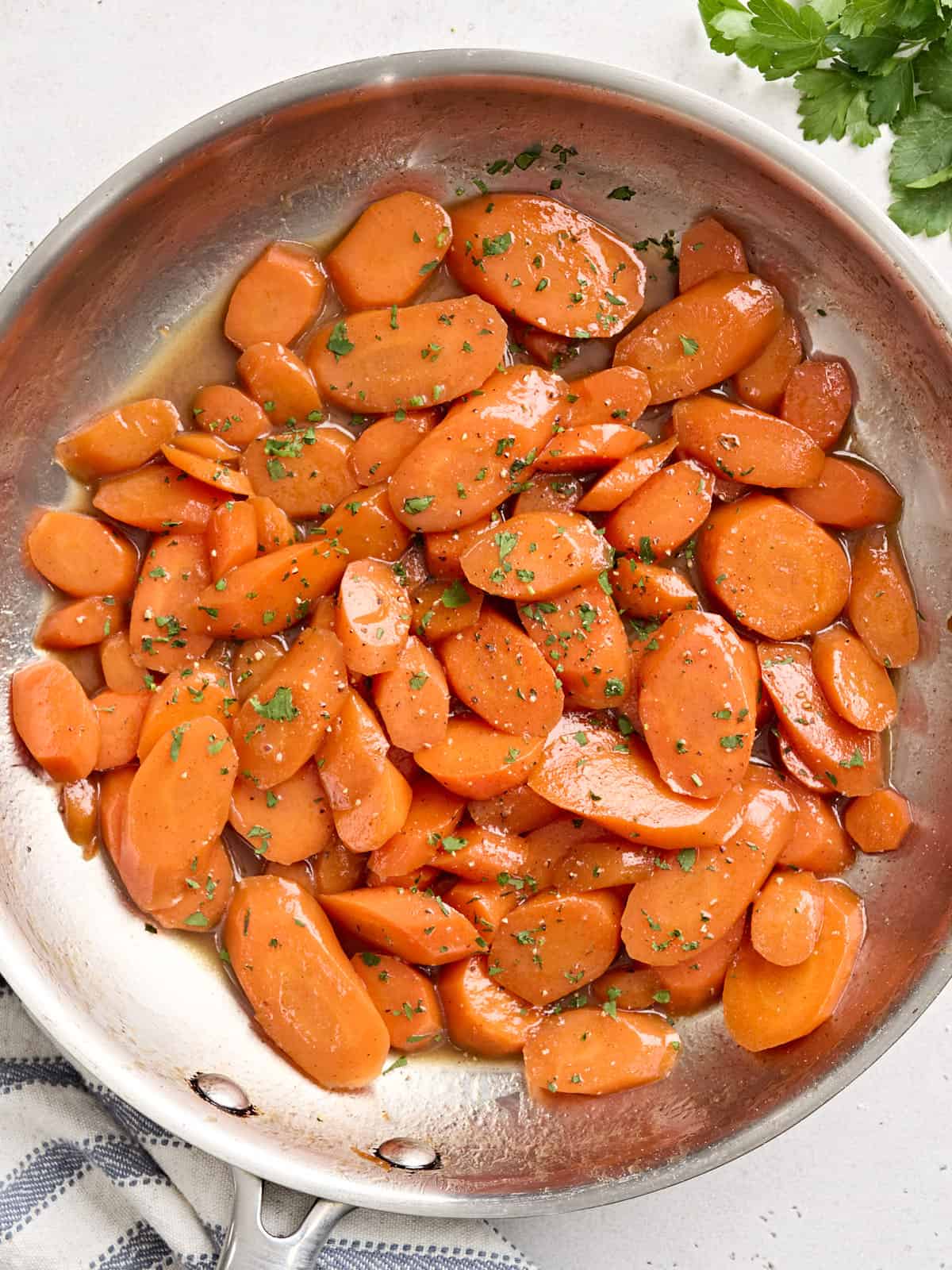 Overhead view of glazed carrots in a sauté pan.