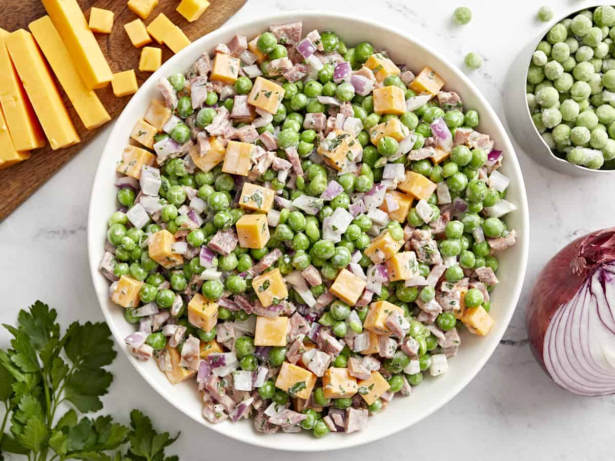 overhead view of pea salad in a white bowl.