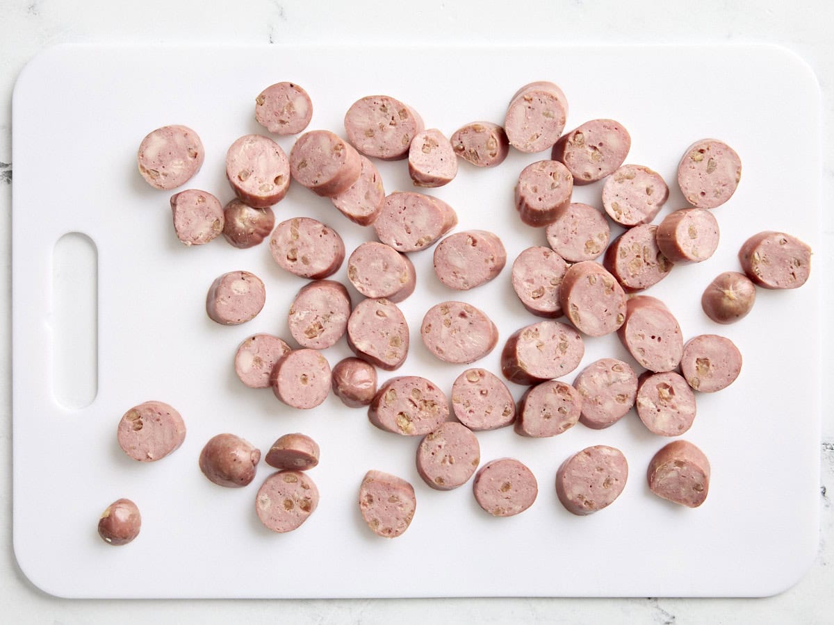 Chicken sausage cut into rounds on a cutting board.