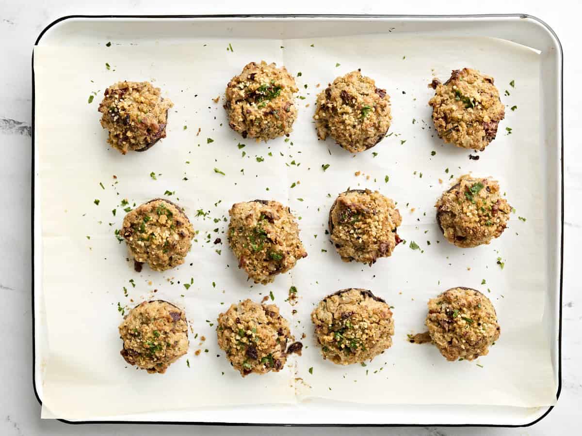 Freshly baked stuffed mushrooms on a baking sheet.