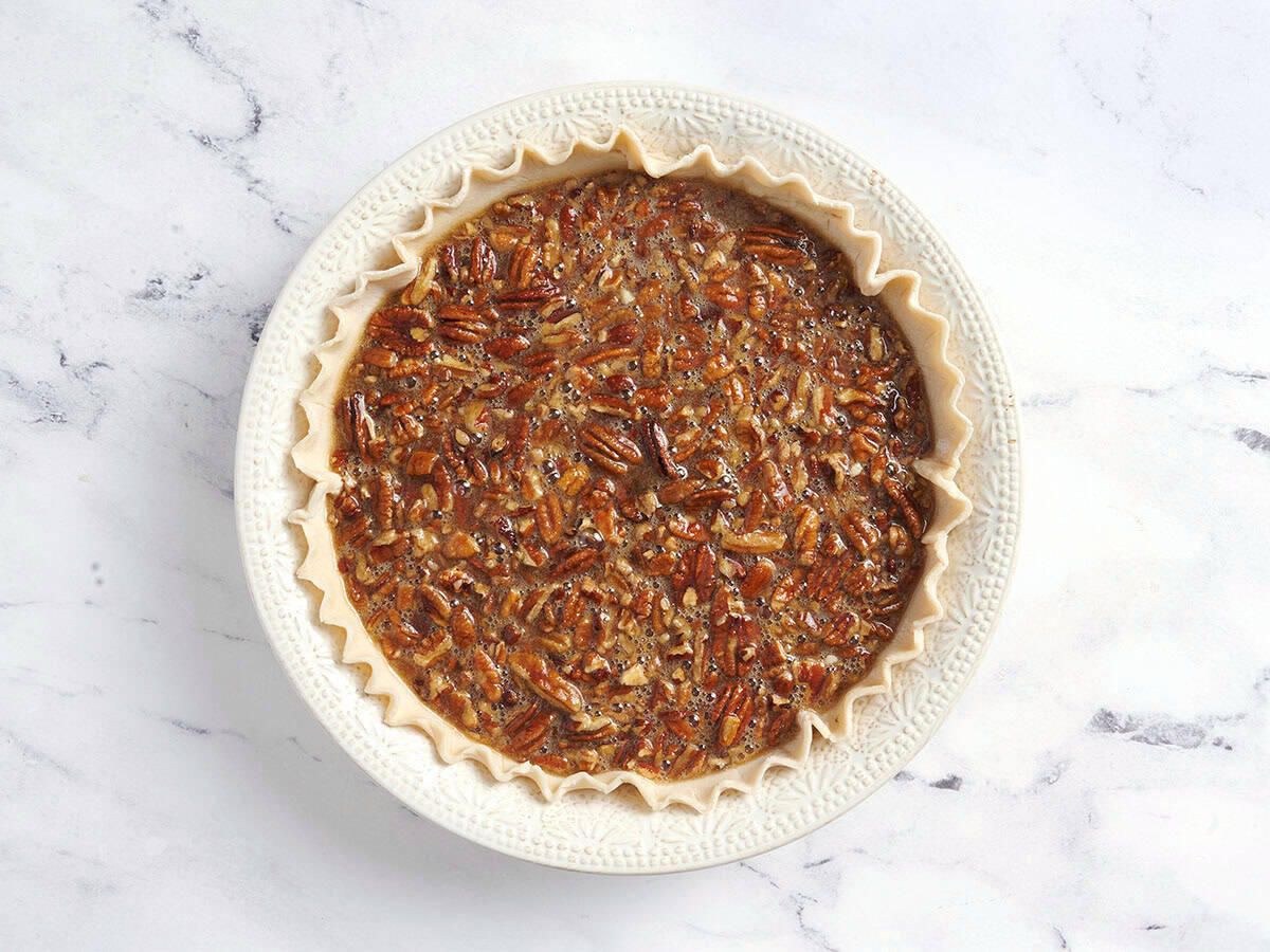 Pecan pie filling in a pie crust.