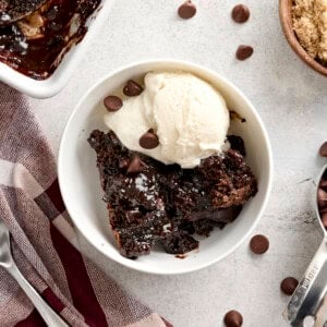 Overhead view of a slice of chocolate pudding cake in a bowl with vanilla ice cream.