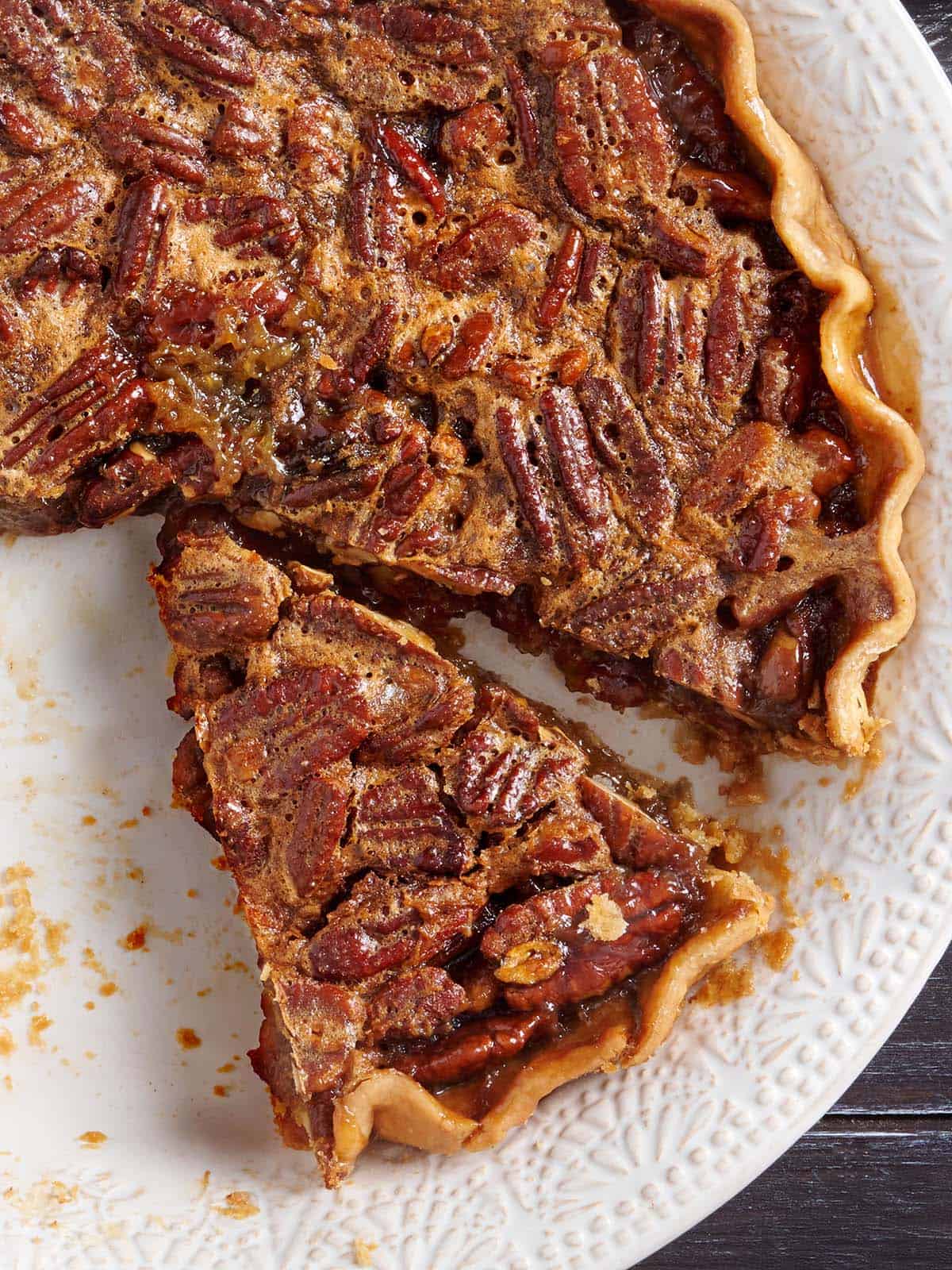 Overhead view of a homemade pecan pie with a slice missing.