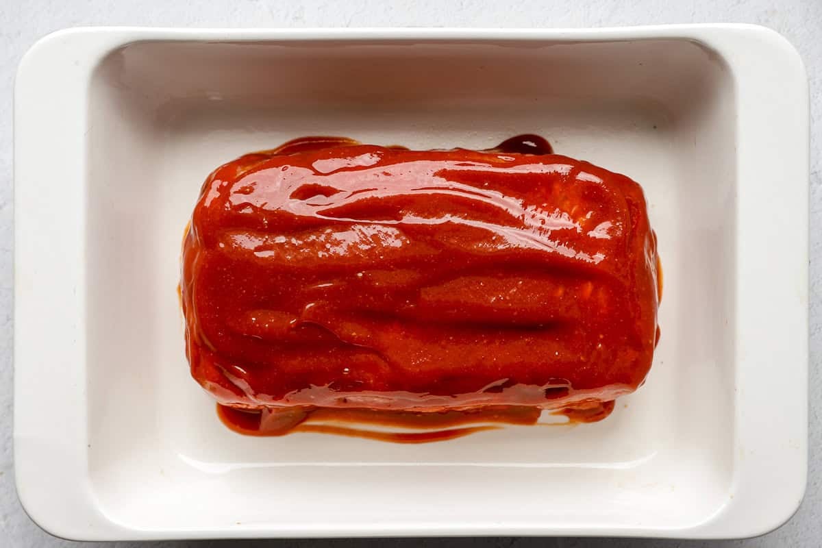Meatloaf with glaze in a baking dish.