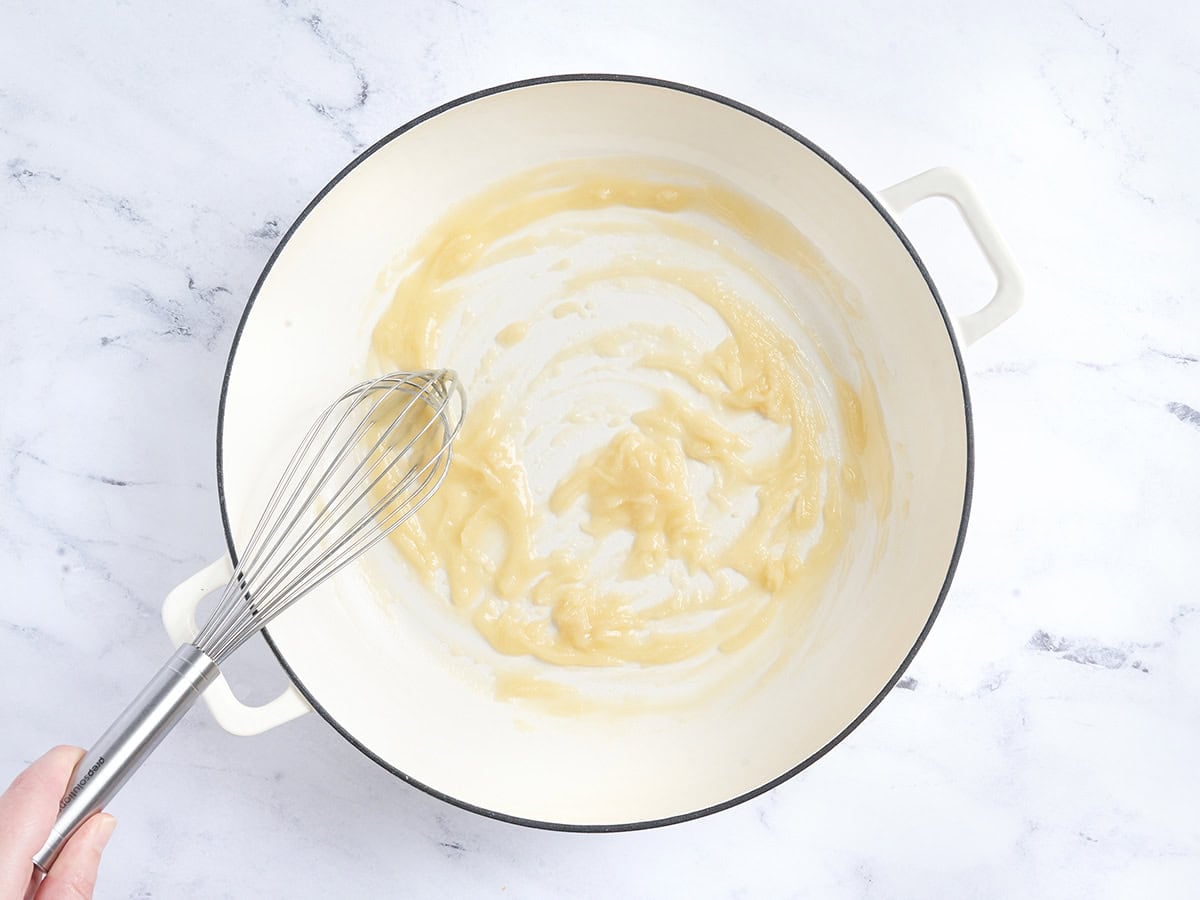 A roux being whisked in a skillet.