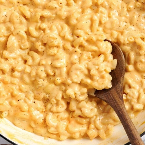 Overhead view of a pot of mac and cheese with a wooden spoon.