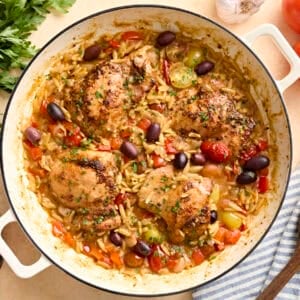 Overhead view of Greek chicken and orzo in a skillet.