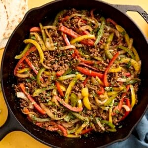 Overhead view of ground beef fajitas filling in a skillet.