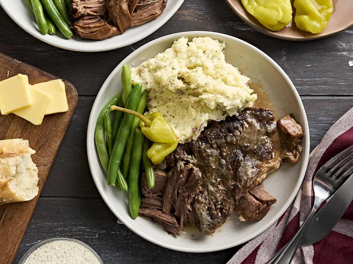Overhead view of mississippi pot roast on a plate with mashed potatoes and green beans.