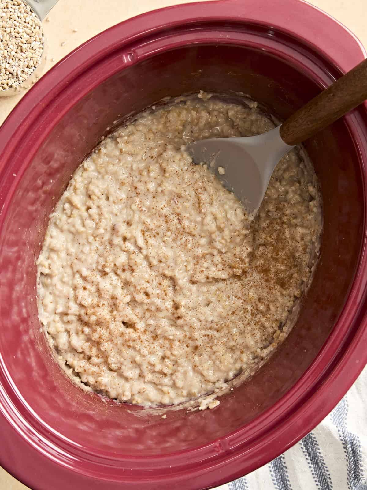 Overhead view of slow cooker steel cut oats in a crockpot with a spoon.