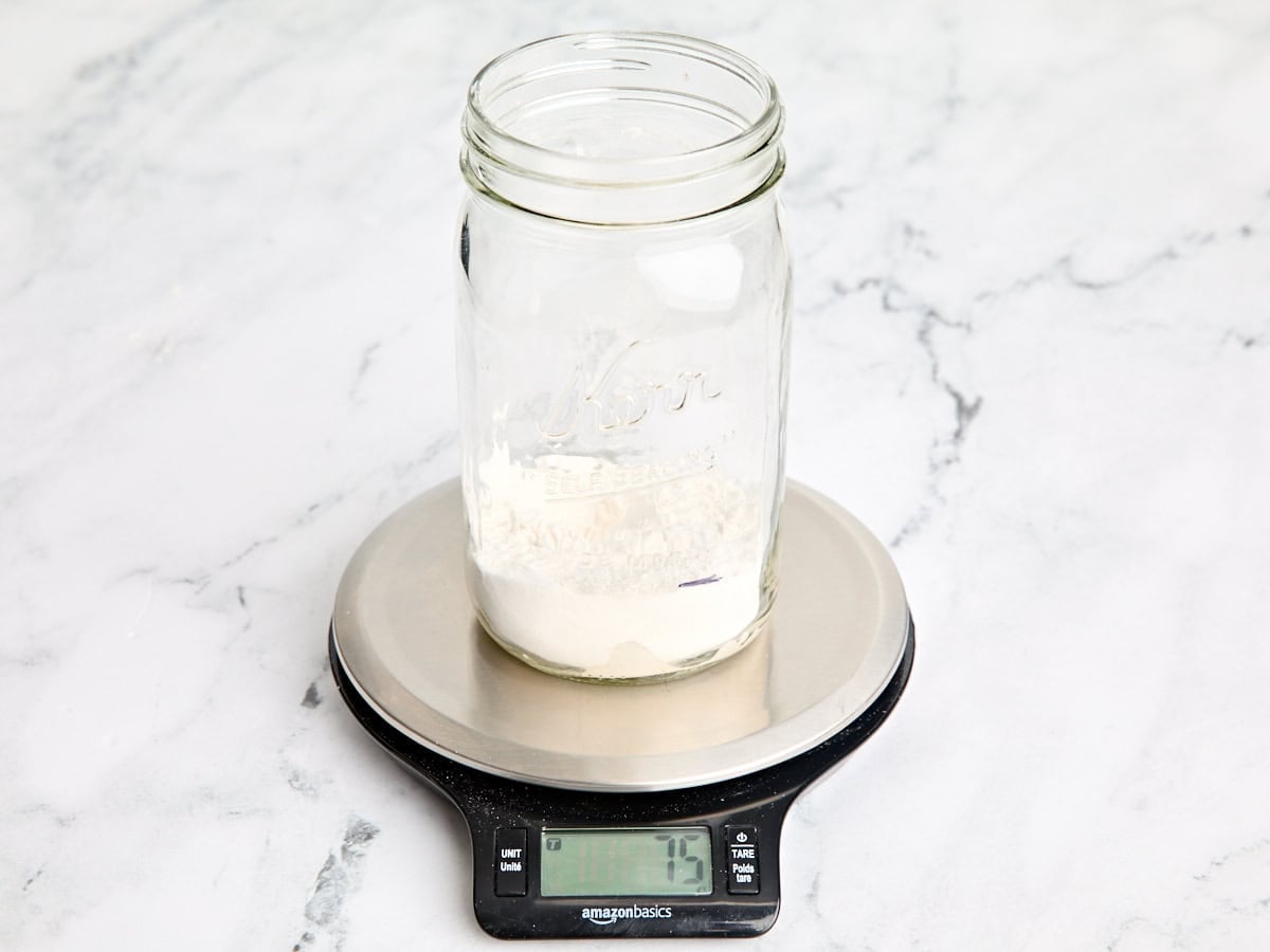 Flour added to an empty mason jar on kitchen scales.