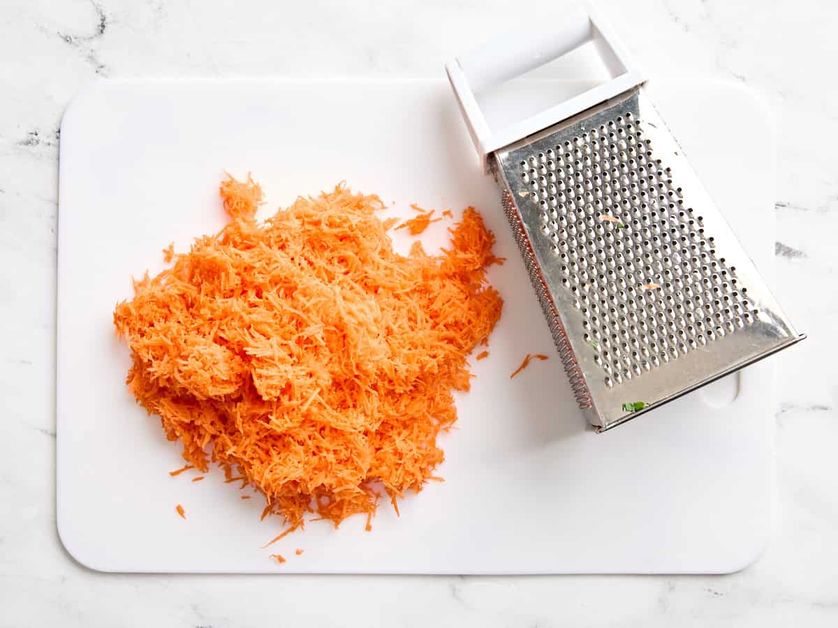 Shredded carrots on a cutting board.