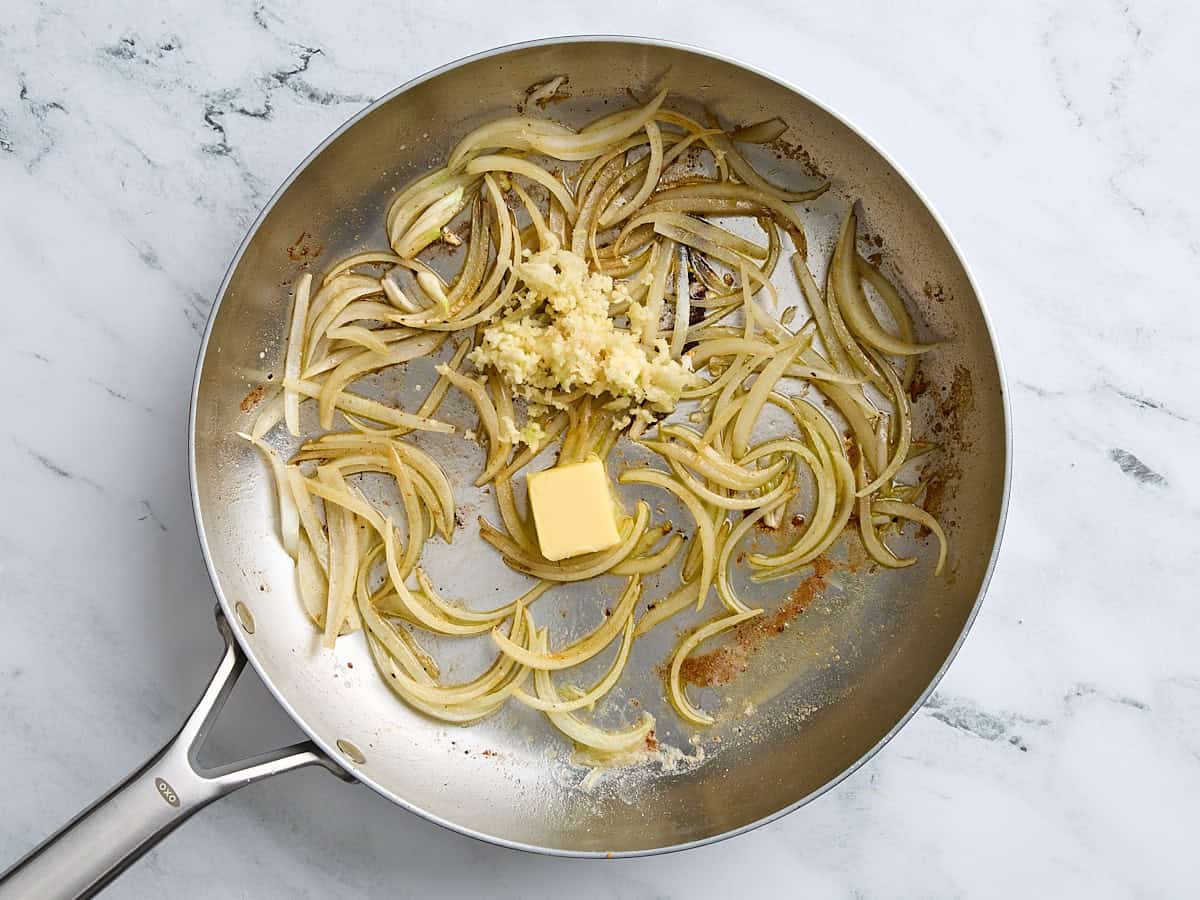 Sliced onions, minced garlic, and butter in a skillet.