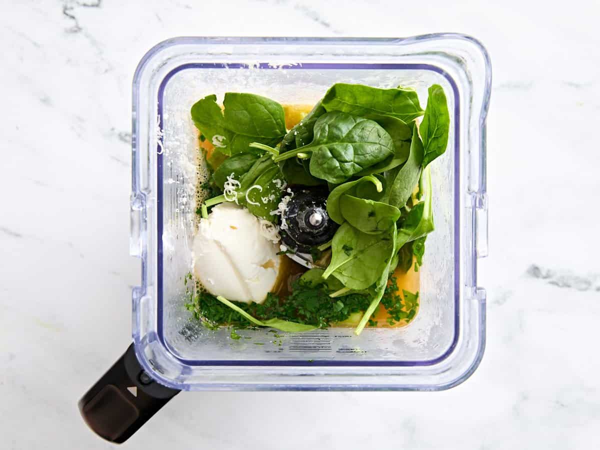 The ingredients to make asparagus soup in a blender.