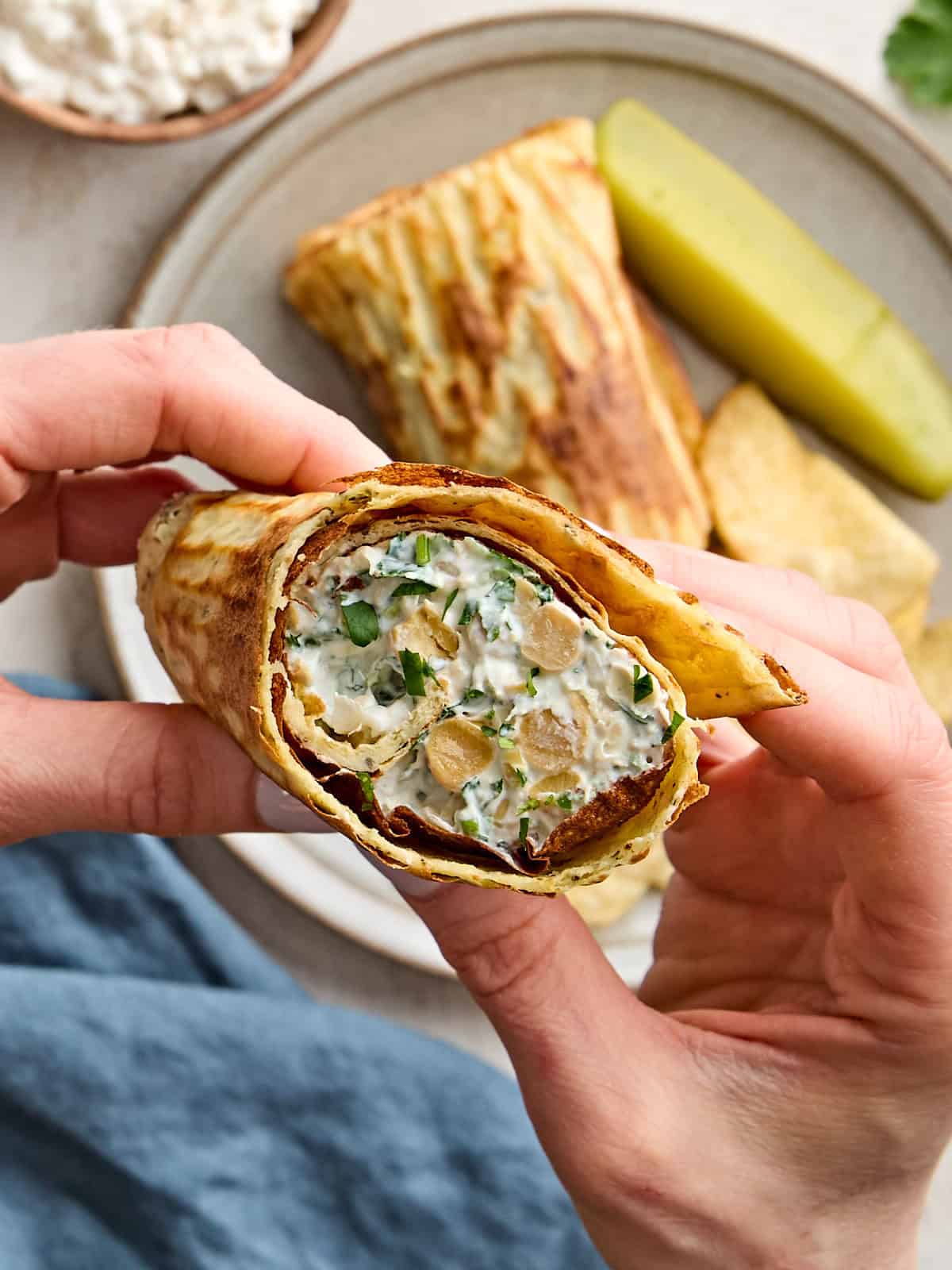 Overhead view of hands holding a cottage cheese wrap.