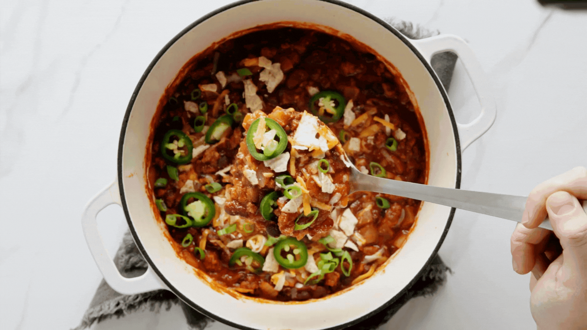 This no-frills basic chili recipe is ready for your personal touch. Learn how to make classic chili and what you can add to make it your own! Budgetbytes.com A pot of Chili with Toppings and a wooden spoon