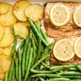 Overhead view of a one pan salmon dinner on a baking sheet.