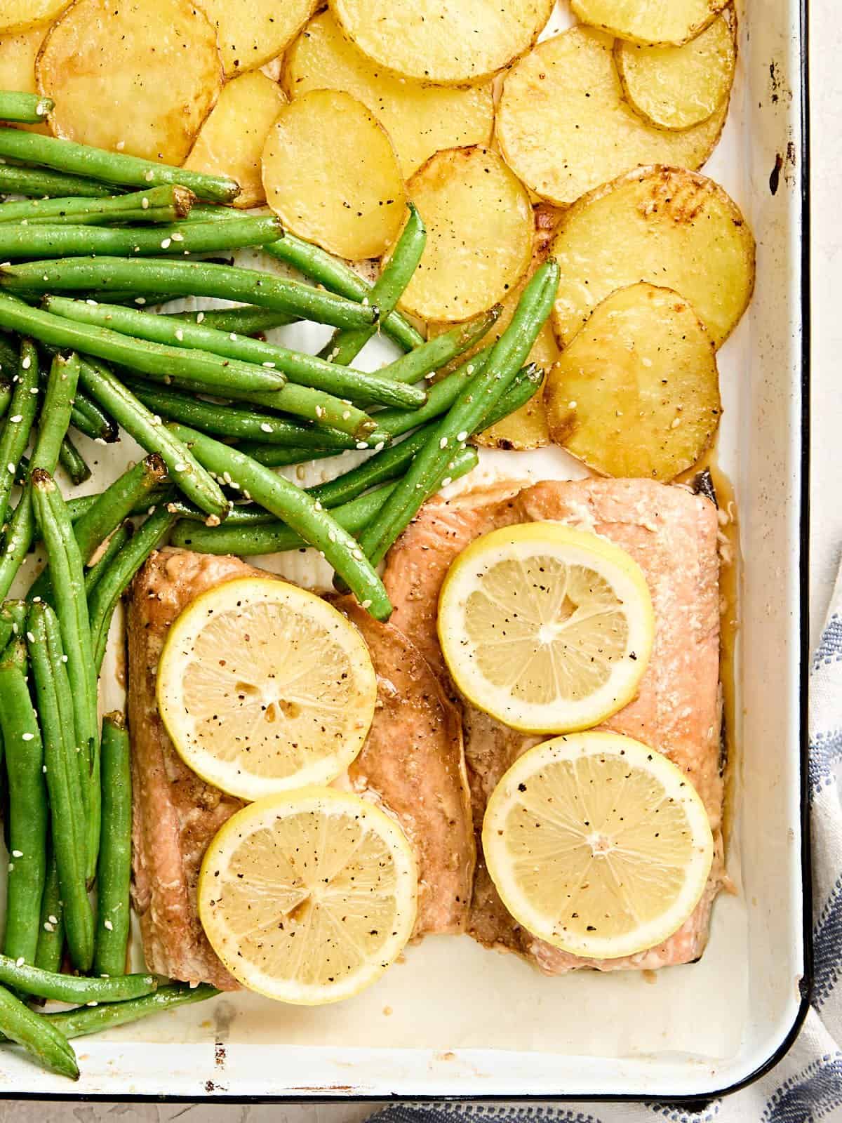 Overhead view of a one pan salmon dinner on a baking sheet.