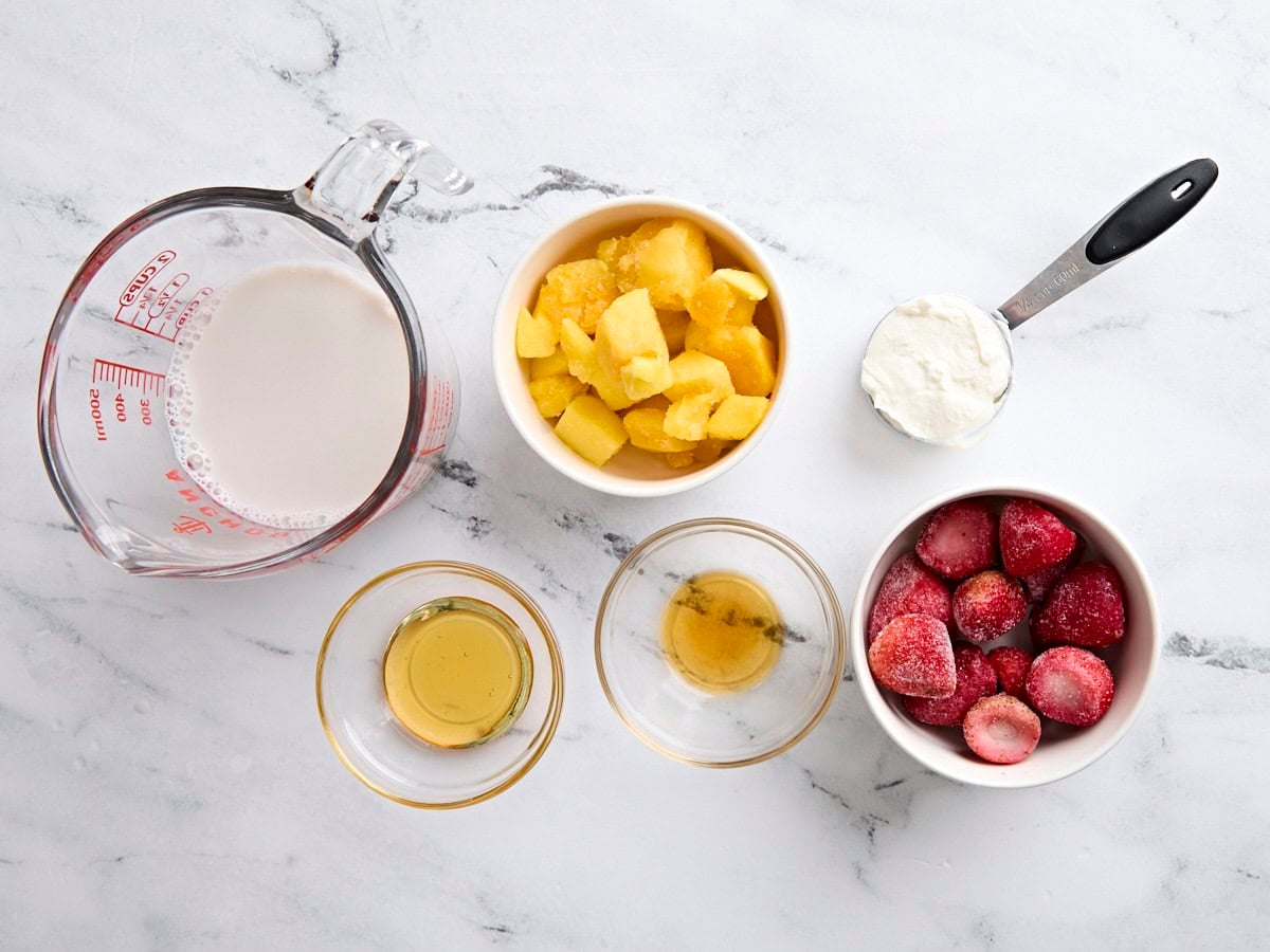 The ingredients to make a strawberry mango smoothie.