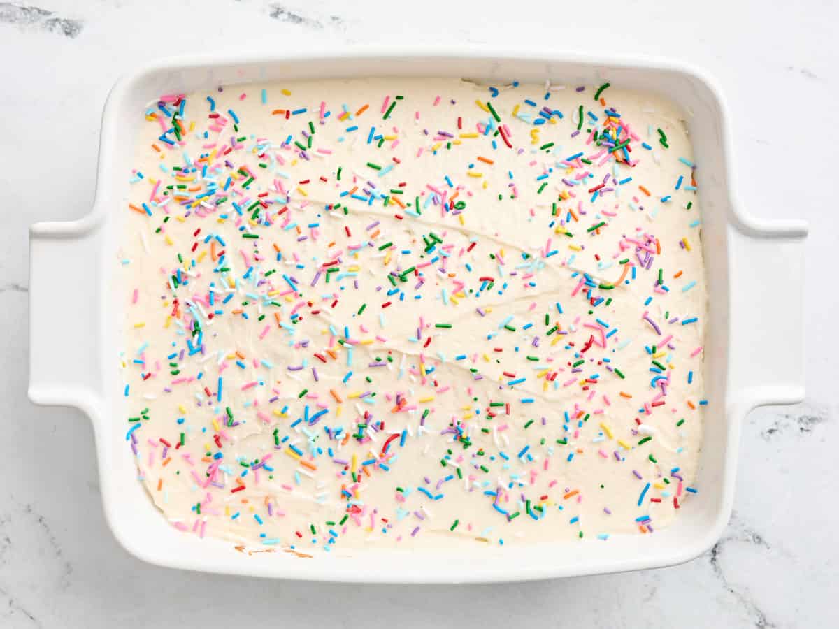 Finished sugar cookie bars in a baking dish topped with rainbow sprinkles.