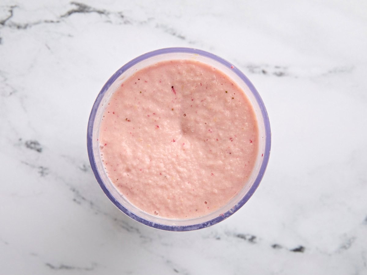 A finished strawberry mango smoothie in a blender.