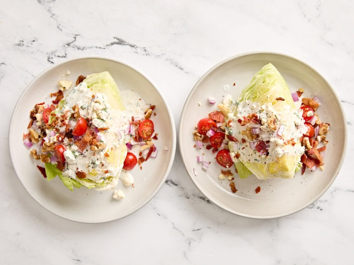 Overhead view of two wedge salads on separate plates.