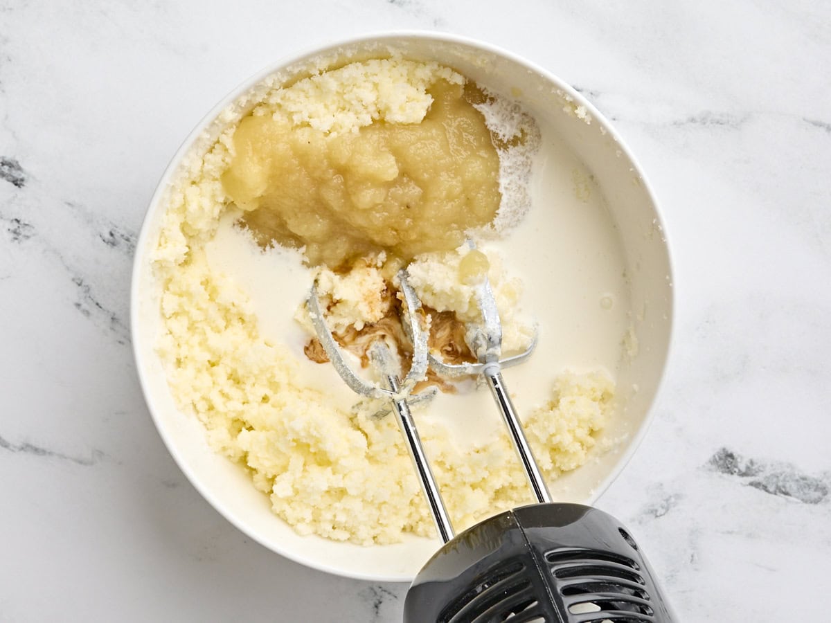 Apple sauce, heavy cream, and vanilla added to a bowl with creamed butter and sugar,