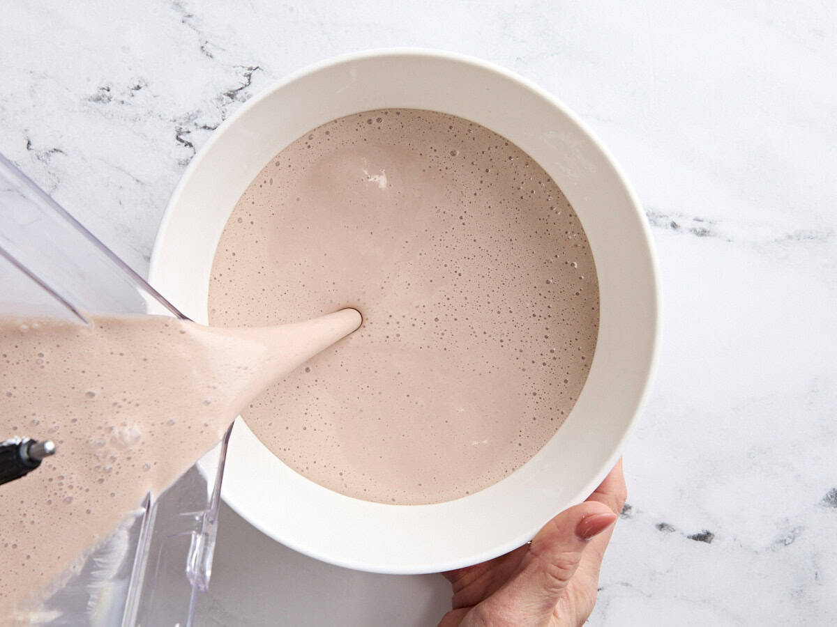 The mixture for a homemade wendys frosty being poured into a bowl.