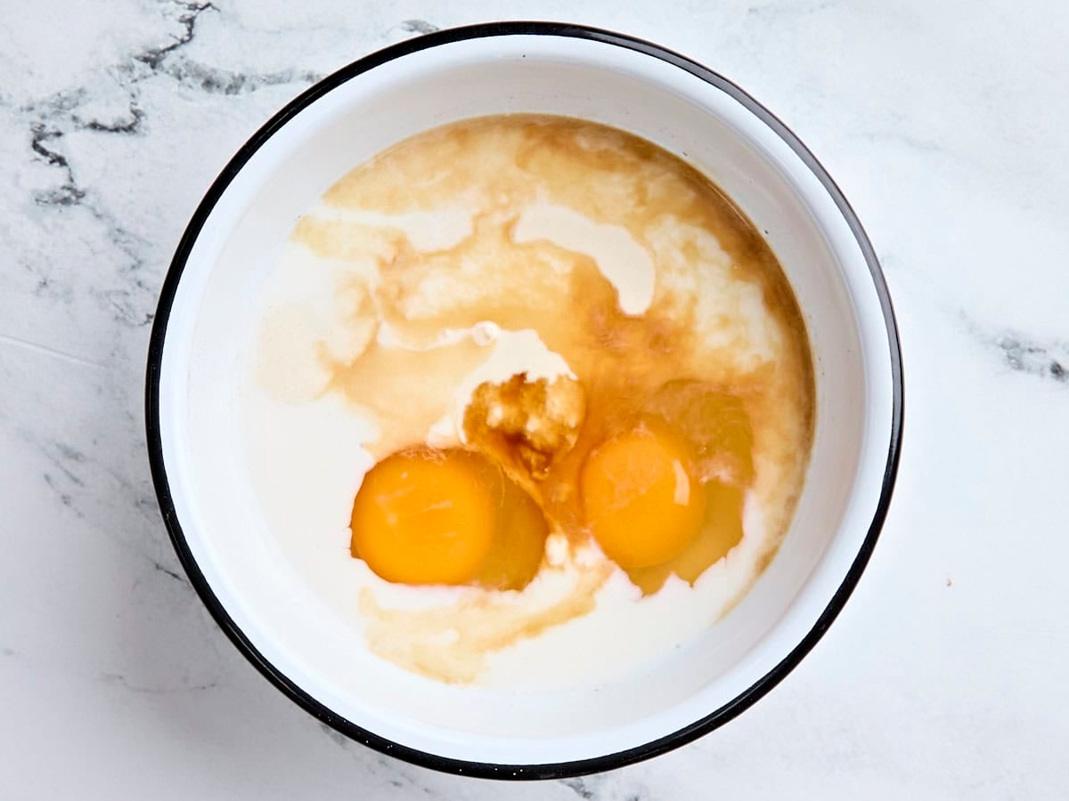 Sourdough discard, eggs, and milk in a mixing bowl.
