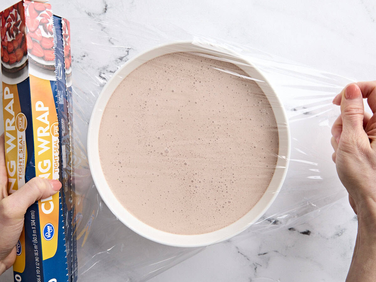 The liquid mixture for a homemade frosty in a bowl covered with plastic wrap.