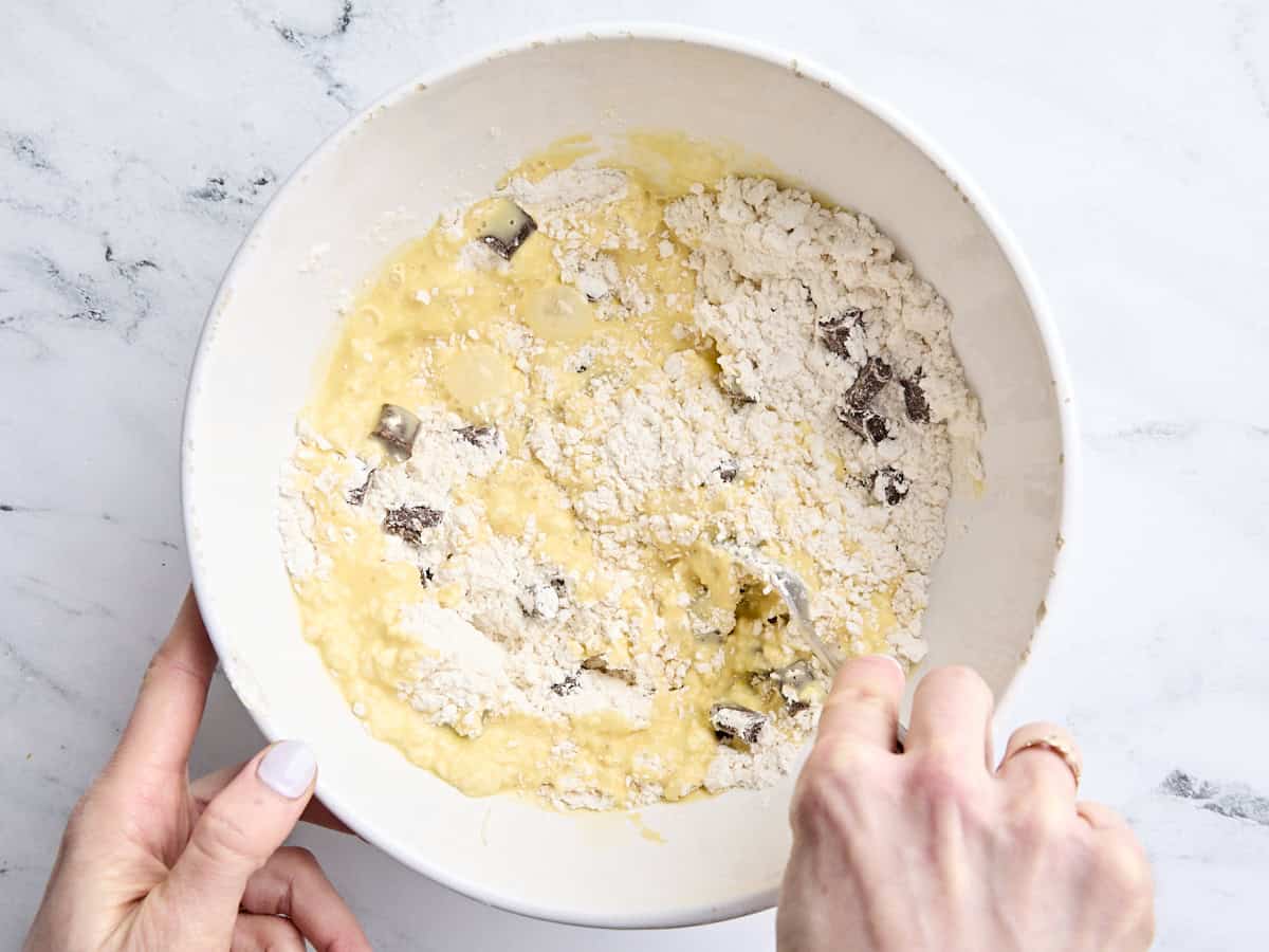 The wet and dry ingredients for sourdough chocolate chip scones being combined in a bowl.