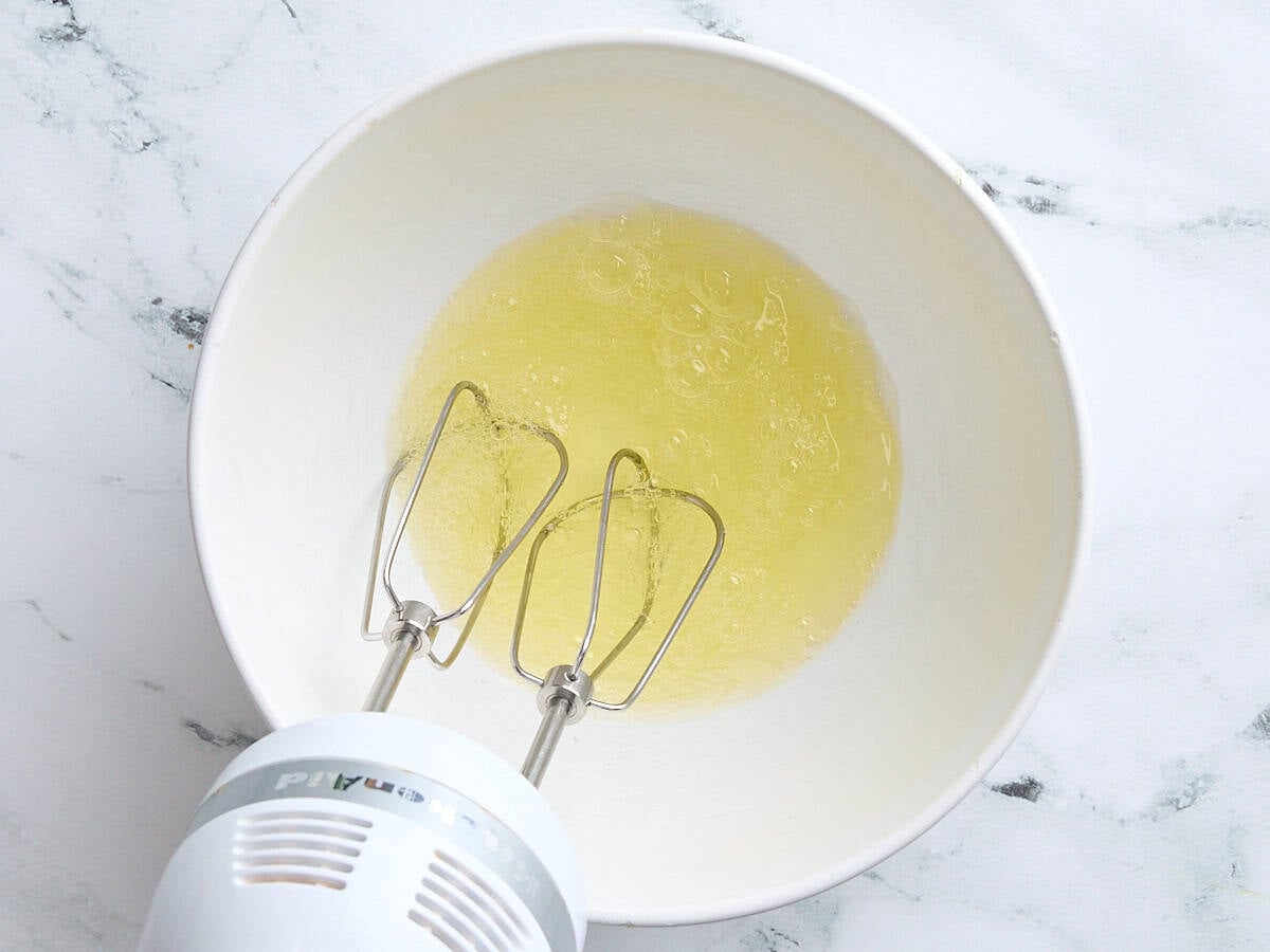 A hand mixer about to whip egg whites in a bowl.