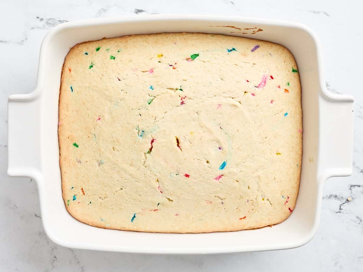 Baked sugar cookie bar base in a baking dish.