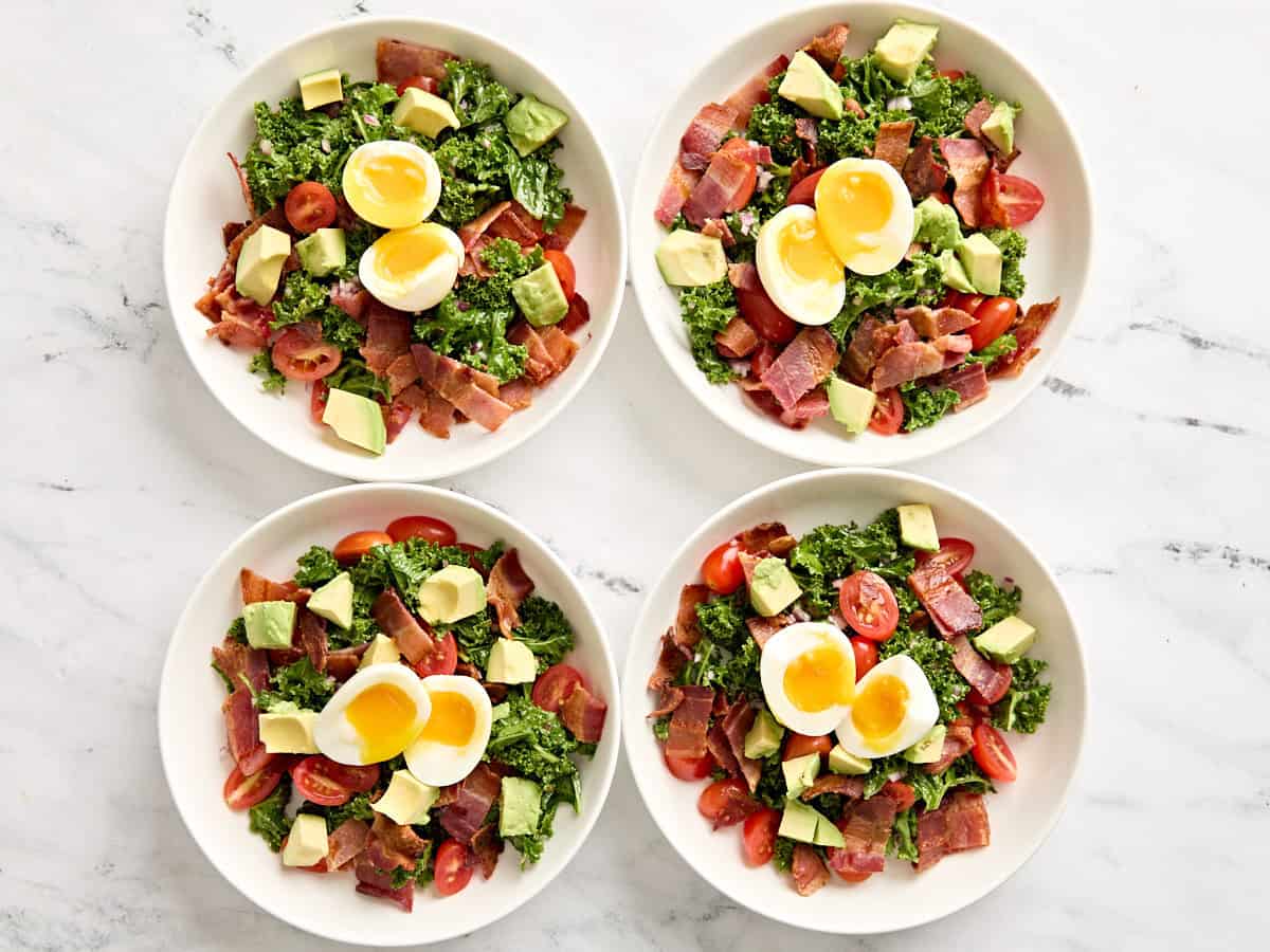 Four finished blt avocado brunch salad bowls.