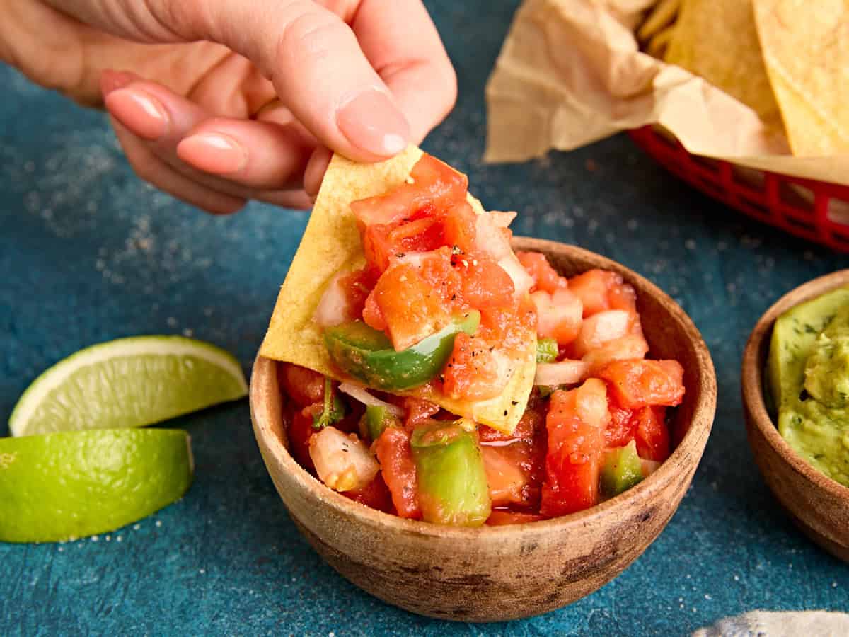 A air fried tortilla chip topped with tomato salsa.