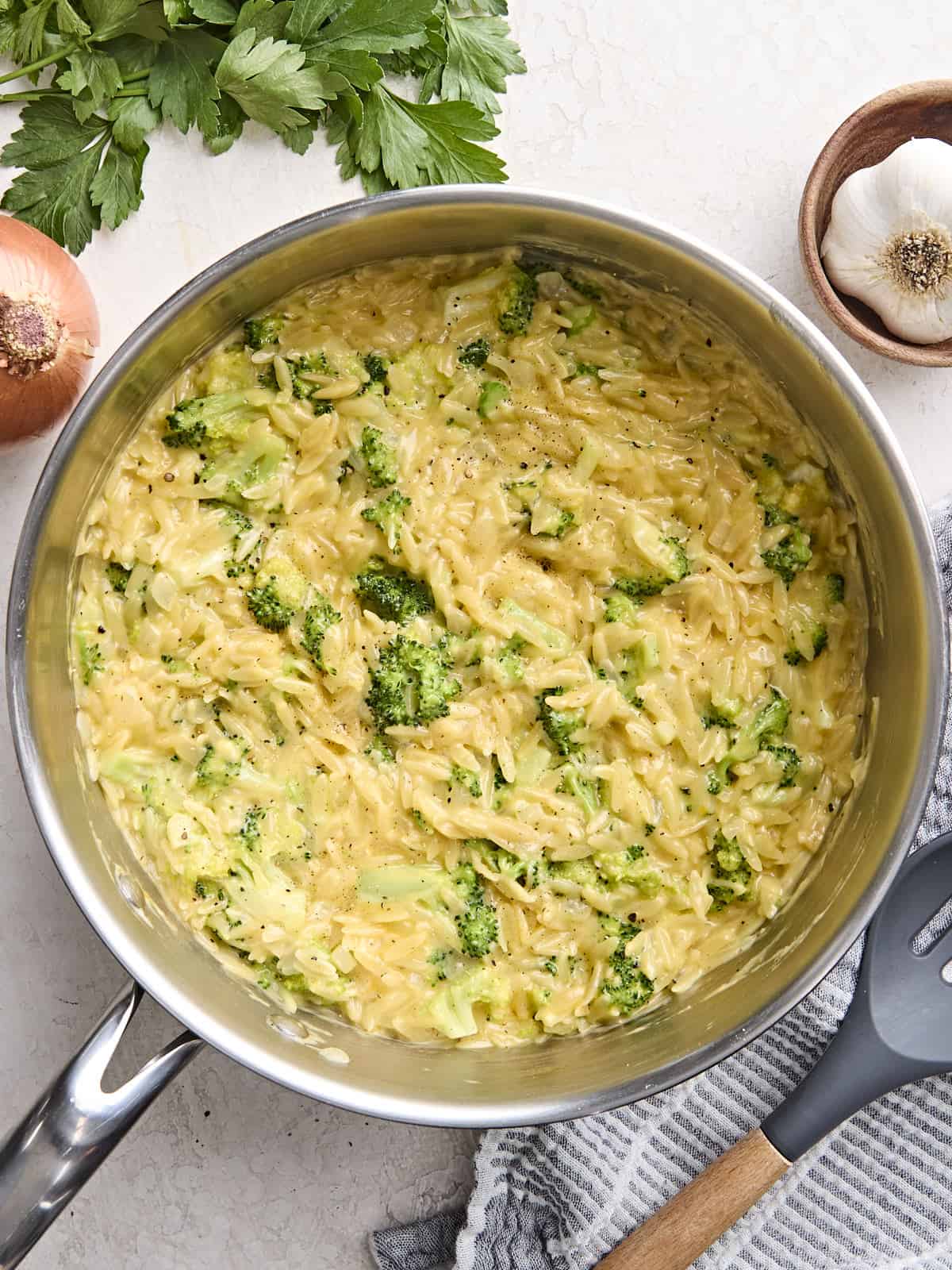 Overhead view of broccoli cheddar orzo in a skillet.